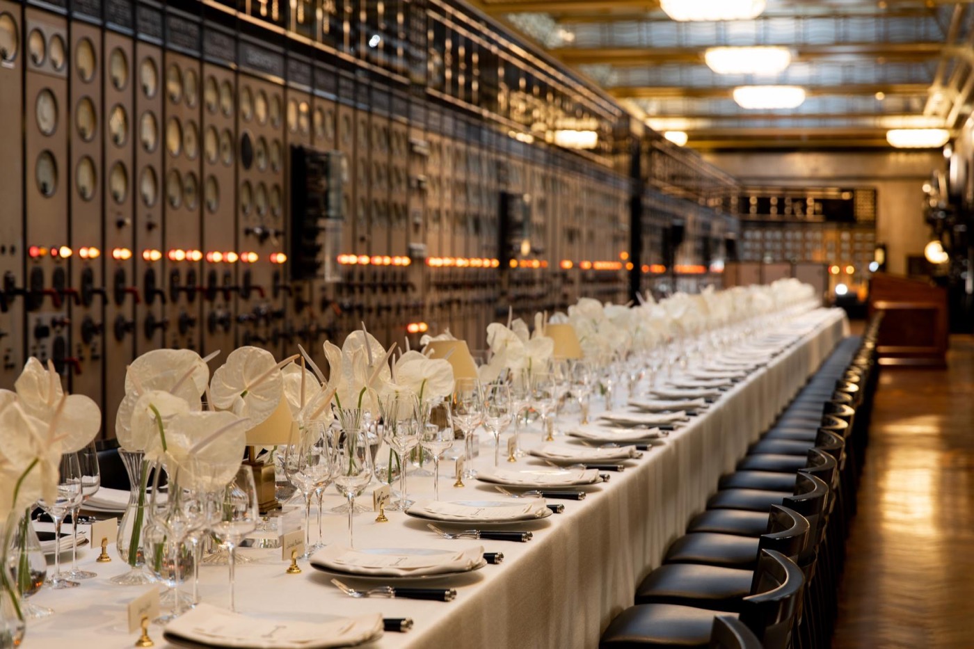 Long elegant dining table setup at Battersea Power Station with white orchids and industrial backdrop